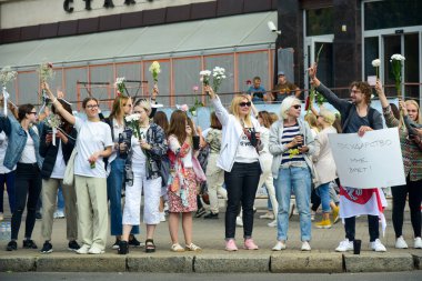 Beyaz bilezikli ve çiçekli insanlar, Belarus, Minsk 'teki Lukashenka hükümetine karşı düzenlenen bir protestoda 13.08.2020.