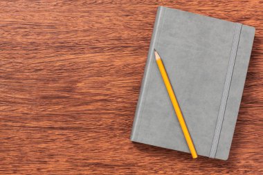 Not defteri, kağıt, kalem, çalışma için kalem veya ofisinde çalışacağım. Ahşap arka plan üzerinde izole.