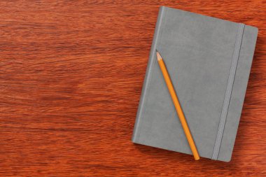 Not defteri, kağıt, kalem, çalışma için kalem veya ofisinde çalışacağım. Ahşap arka plan üzerinde izole.