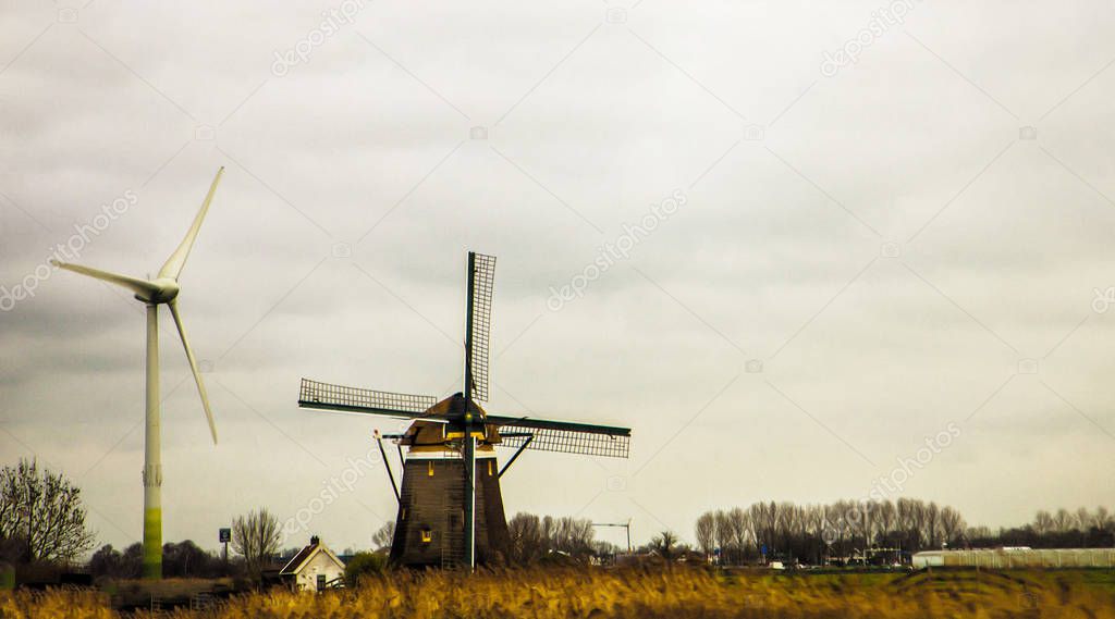 two windmills staying at the fild in Holland, one is very old and traditional for this place. 