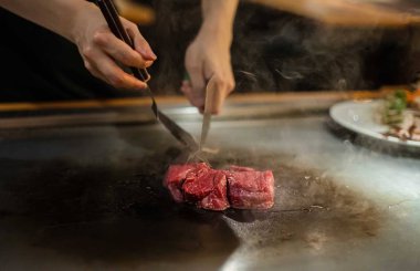 Bir Japon restoranında teppan gösterisi, müşterinin önünde doğrudan yemek pişirmek, balık, pirinç, et, sebze