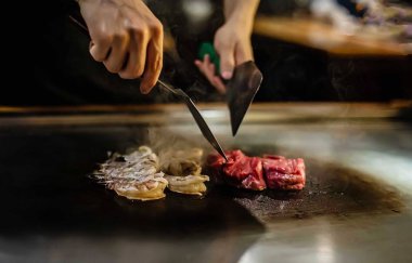 Bir Japon restoranında teppan gösterisi, müşterinin önünde doğrudan yemek pişirmek, balık, pirinç, et, sebze