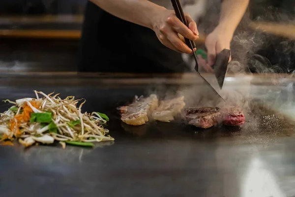 teppan show in a Japanese restaurant, cooking directly in front of the client, fish, rice, meat, vegetables