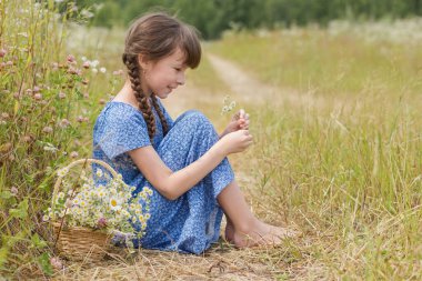 Papatya çayı ve bir sepet çiçekli sevimli kızın yaz portresi.