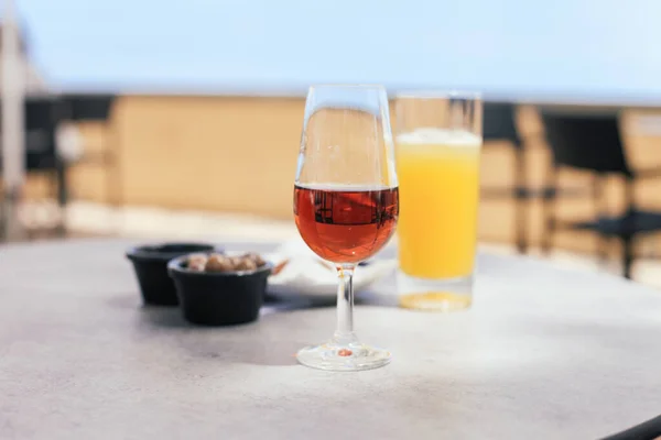 Masada bir bardak Madeira şarabı ve pancha. Funchal 'da geleneksel Portekiz içkileri.
