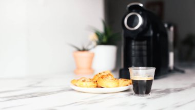 Bir bardak espresso ve tarçınlı kahve makinesi. Basit bir kahvaltı.