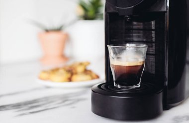 Bir fincan espresso ve taze tarçınlı kahve makinesi, basit bir kahvaltı.