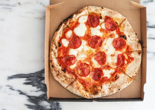 Kutuda taze İtalyan pizzası, mermer arka plan.