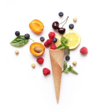Meyve ve böğürtlenli bir koni - limon, kayısı, ahududu, yabanmersini, üst manzara, beyaz arka plan 