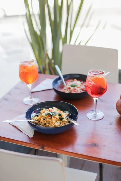 Bir bardak Aperol ve taze pişmiş makarna ile Campari.