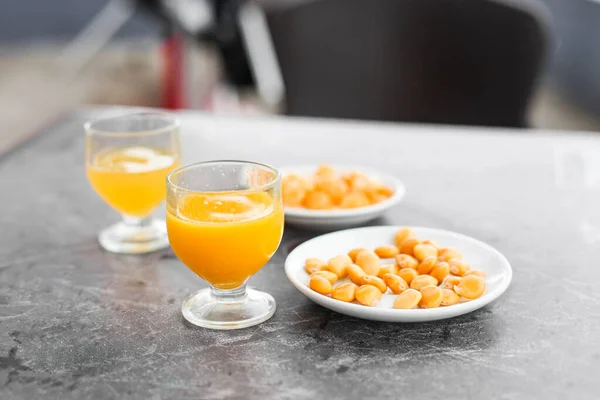 Traditional orange drink from Madeira poncha with a snack lupines \