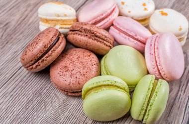 Lezzetli çok renkli Fransızca macaroons veya ahşap arka plan üzerinde macaron