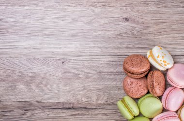 Lezzetli çok renkli Fransızca macaroons veya macaron bir ahşap arka plan whith yere metin ekleme için. Kopya alanı