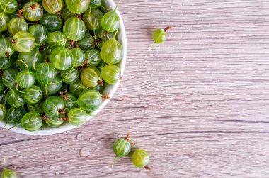 Bektaşi üzümü alan ahşap bir zemin üzerine beyaz tabak içinde olgun meyveler metin ekleyin. Düz yatıyordu, en iyi görünüm, kopya alanı