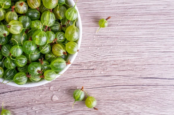 Bektaşi üzümü alan ahşap bir zemin üzerine beyaz tabak içinde olgun meyveler metin ekleyin. Düz yatıyordu, en iyi görünüm, kopya alanı