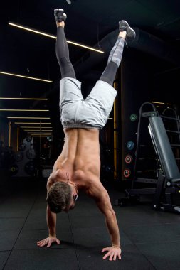 Spor salonunda adam ellerinin üstünde duruyor. Üstten görünüm, kopya alanı