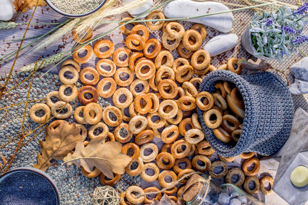 Flat lay with a lot of bagels on the wooden background and in a knitted bag.