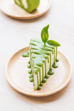 Yeşil çay rulo pasta ahşap tabak, sığ derinliği alanı, çay yaprakları odak üzerinde kapatın.