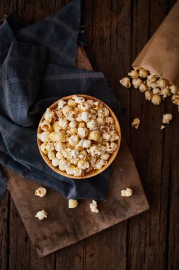 Tahta zemin üzerinde karamel olan lezzetli patlamış mısır.