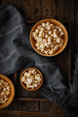 Tahta zemin üzerinde karamel olan lezzetli patlamış mısır.