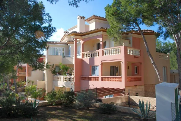 Yeşil ağaçlı pembe villa.
