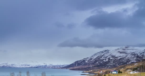 アイスランドのAkureyriでの雪の山フィヨルドの上の雲の圧延時間の経過 — ストック動画