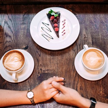 Arka plan üzerinde kafe holding yakın çekim kadın ve erkek eller masa
