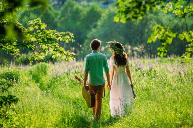 bir erkek ve bir kız aşık derin otların arasında yürüyüş