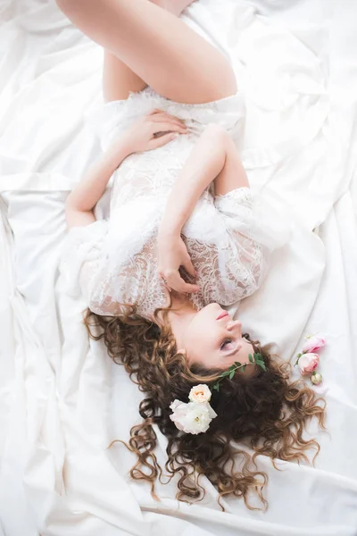 年轻的新娘躺在床上的白色 婚礼的早晨 — 图库照片