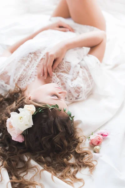新娘躺在白色的 Peignoir 一个女孩躺在她的背部 她的手压在她的胸口 — 图库照片