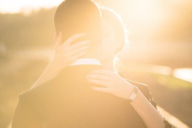 Sıcak ışıklı fotoğraf, kadının elini adamın boyun ve omuz kucaklayan