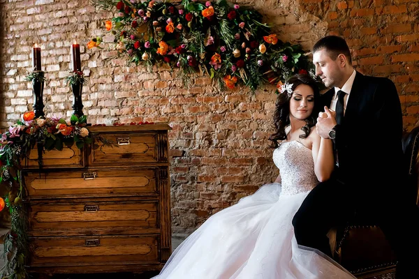 Seduta Sposa Tenendo Mano Del Suo Uomo Sorridente Cassettiera Muro — Foto Stock