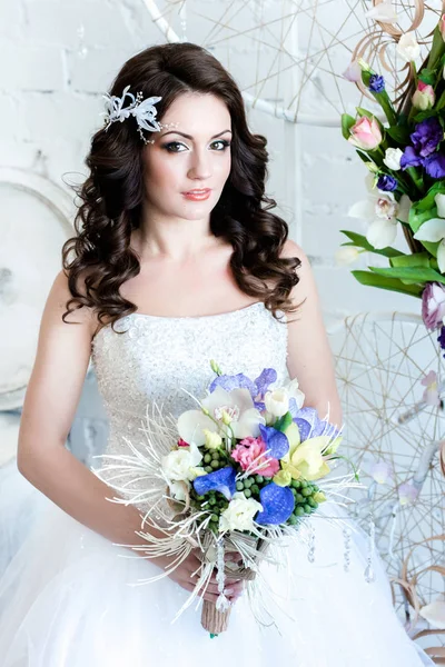 Portrait of the bride. A beautiful bride with flowers looking at us happily