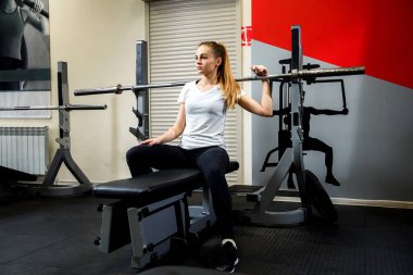 Ciddi sporcumuz bir simülatör bir spor salonunda oturuyor. Akbaba ile eğitimden sonra dinlenme