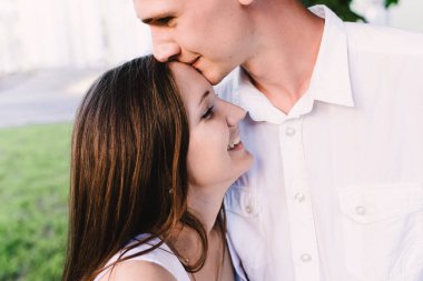 Mutlu adam onun öpüşme kızlar alnına hafifçe gülüyor. Erkek kız öpücük