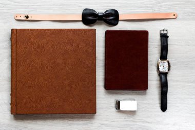 En centilmen kümesinin görünümü: deri kelebek, saatler, dizüstü bilgisayar, flash sürücüde modern ahşap arka plan. Erkek aksesuarlar kümesi. Metin için yer kopyalayın