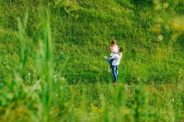 Yakışıklı adam kız arkadaşı onun elinde, onun omuzlarına ellerini tutuyor, onlar birbirlerine çok güzel, yeşillik içinde izole arıyoruz