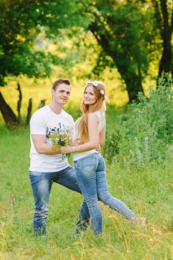 Mutlu adam onun kız tekrar fotoğraf için bir çift ayakta sarılma ne mutlu ki, bunların arkasındaki yeşil ağaçlar gülümsüyor