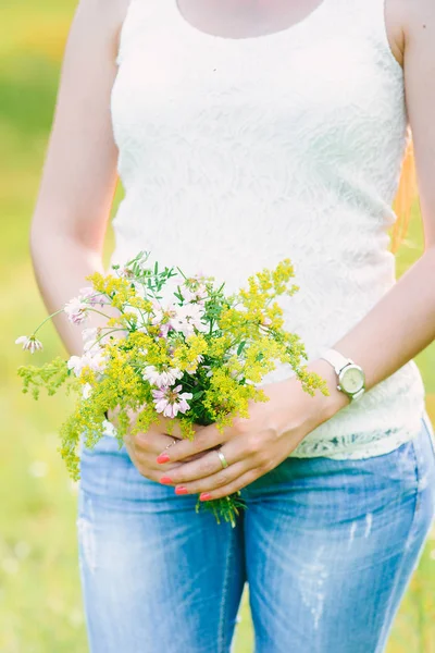 女性の優しい手のワイルドフラワーの花束 — ストック写真
