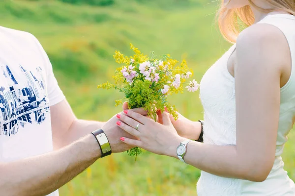 男子呈现可爱的野花花束给他的女孩 浪漫的 绿色的背景 — 图库照片