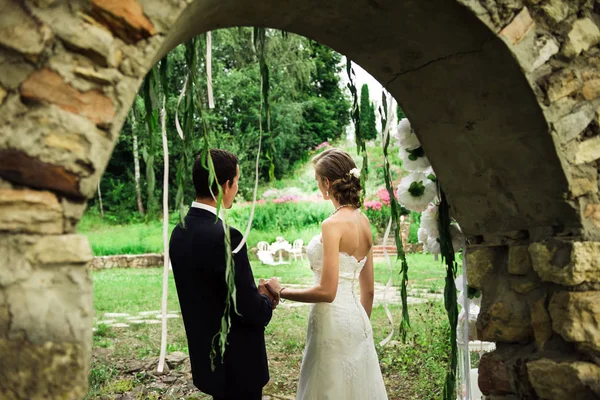 View Newlyweds Stone Arch Holding Hands Looking One Way Together — Stock Photo, Image