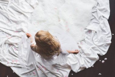 Güzel bir kadın onu dantel iç çamaşırı, sarı kıvırcık saçlı sallayarak, beyaz kürk ve ayaklarının altında bez alarak üst katında. Kadın portresi üstten görünüm