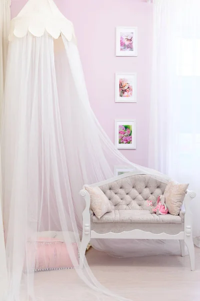 漂亮的米色沙发上覆盖着一个小的透明布从一个美丽的女孩房间的树冠 室内少女房 — 图库照片