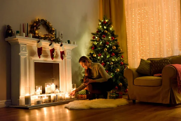 居心地の良い明るいクリスマスの素敵な女性は 暖炉の蝋燭の修正の部屋を飾った クリスマスの部屋のインテリア デザイン Copyspace ライト キャンドルで飾られたクリスマス ツリーと屋内の暖炉 — ストック写真