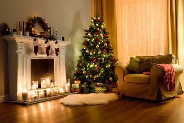 A cozy living room lighted with numerous lights decorated ready to celebrate Christmas. Christmas room interior design, Xmas tree decorated by lights, candles and garland lighting indoors fireplace