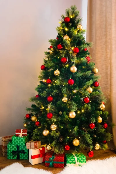 美妙的圣诞树上装饰着传统的红色和黄色的玩具 许多礼物在树下 空气中的舒适气氛 — 图库照片