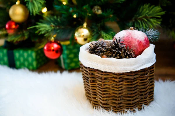 篮子里放着松树锥和红水果站在白色毛茸茸的地毯下装饰圣诞树下 复制空间 新的一年和圣诞装饰品在编织篮与松树锥 — 图库照片