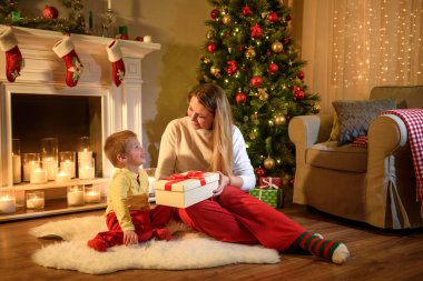 Genç Anne oğlunu bir yeni yıl hediyesi, veren çok mutlulukla gülümsüyor, Noel geliyor