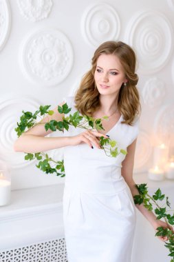 Beyaz poz içinde taze Bayan düşünceli yeşil dal, doğal güzellik tarafından sarıldı. Sağlık ve güzellik kavramı