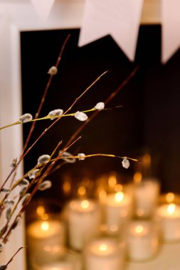 Şömine mum. A kapatmak bakmak bir Kukum üzerinde ters beyaz mumlar yanan şöminenin dalları. Paskalya